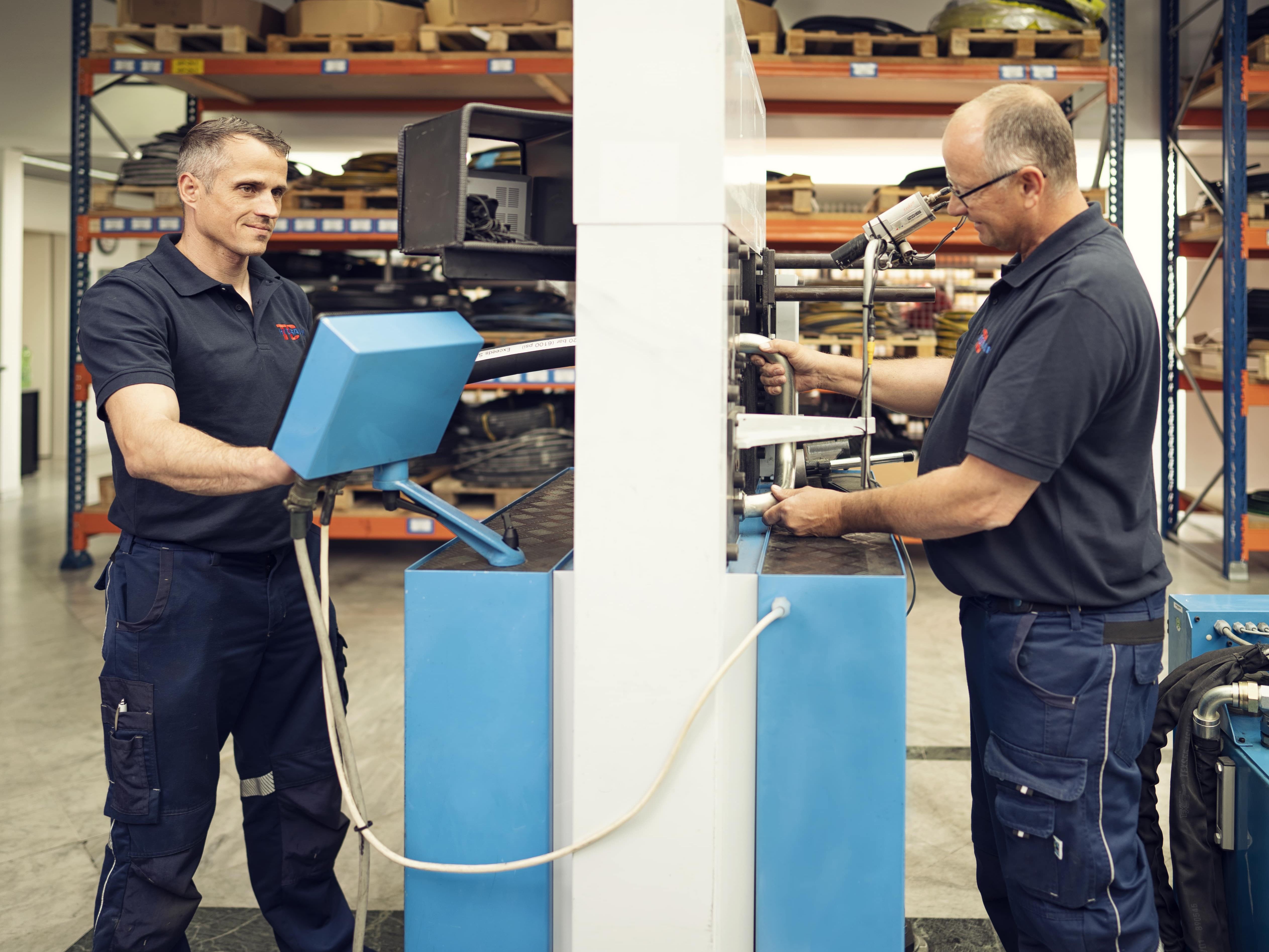 Schlauchfertigung, Sonderfertigung, Produktion, zwei Kollegen produzieren an der Maschine Finn Power 