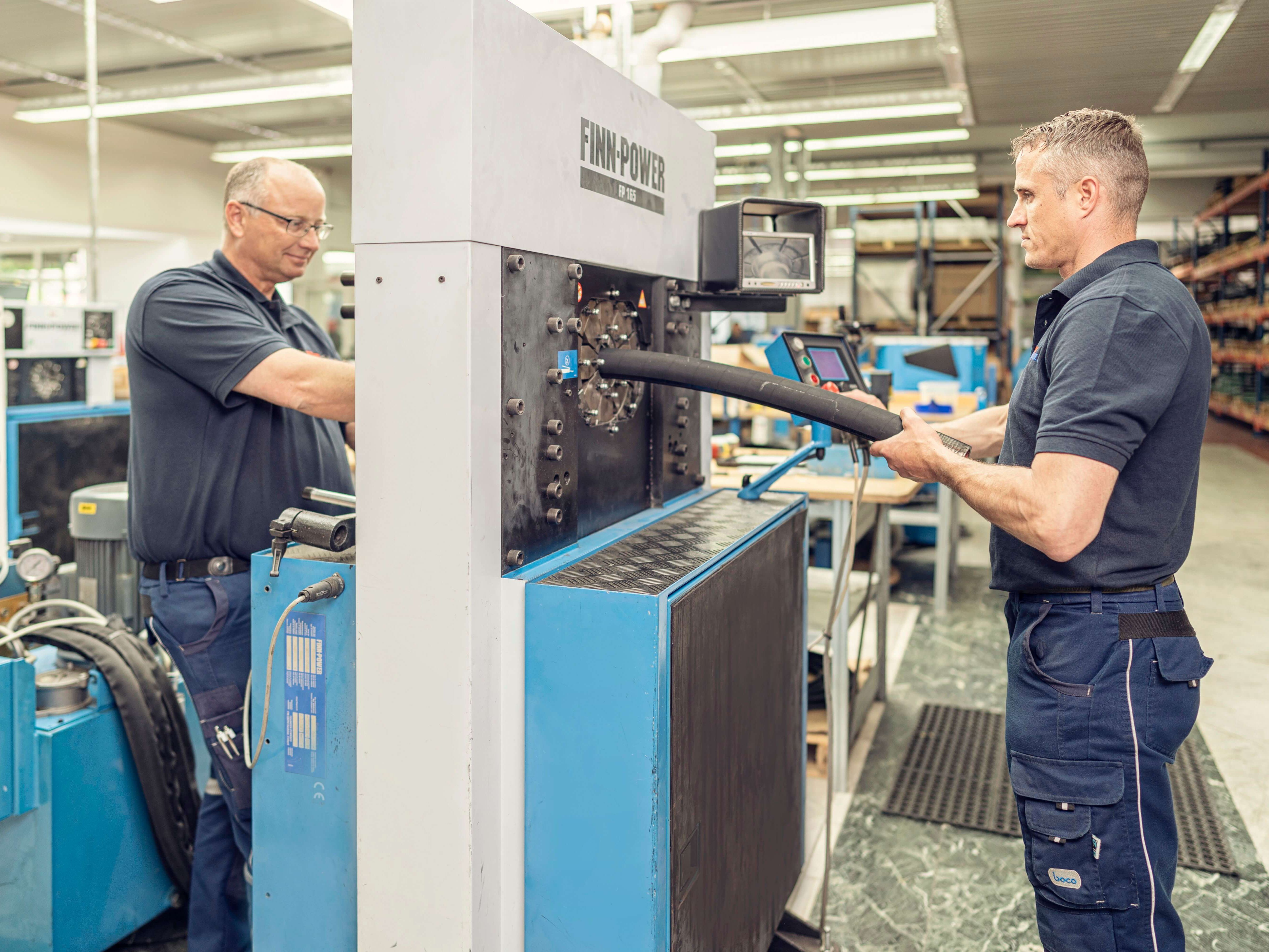 Schlauchfertigung, Sonderfertigung, Produktion, zwei Kollegen produzieren an der Maschine Finn Power 